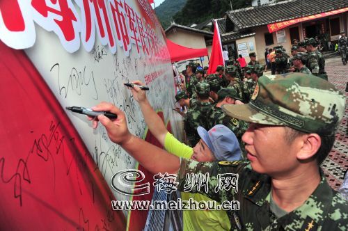 抵達終點多寶坑站，軍民在展板上簽名 。

