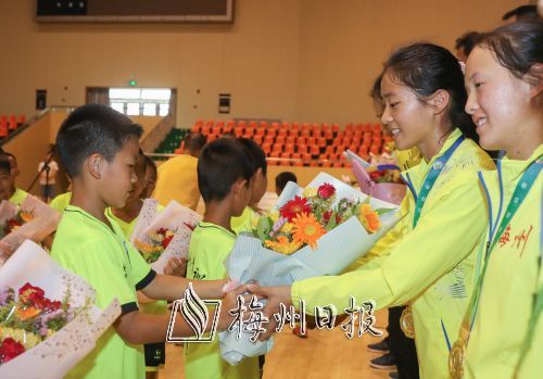 小隊員鮮花迎接載譽歸來的運動員。(林翔 攝)